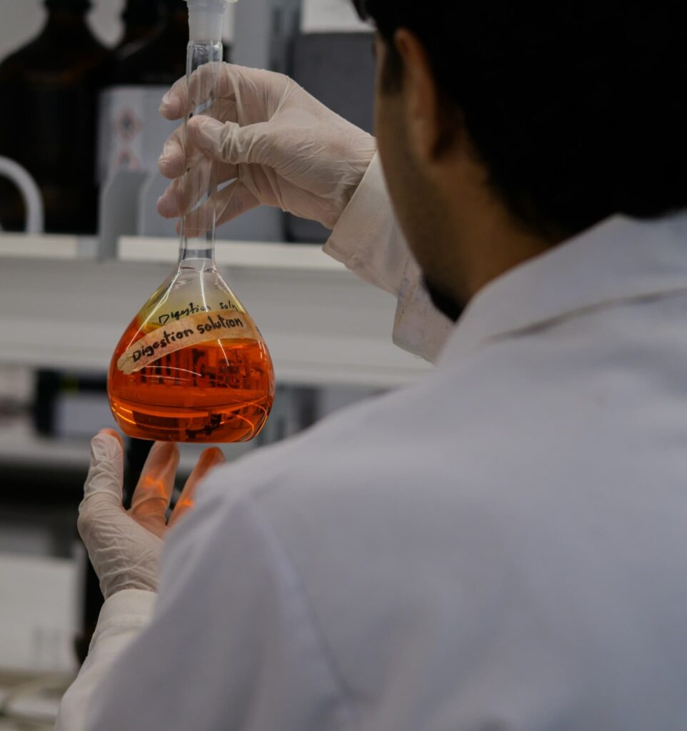 Scientist working in a laboratory while handling chemical samples, representing scientific research, professional expertise, innovation, and employment-based immigration opportunities in specialized fields.