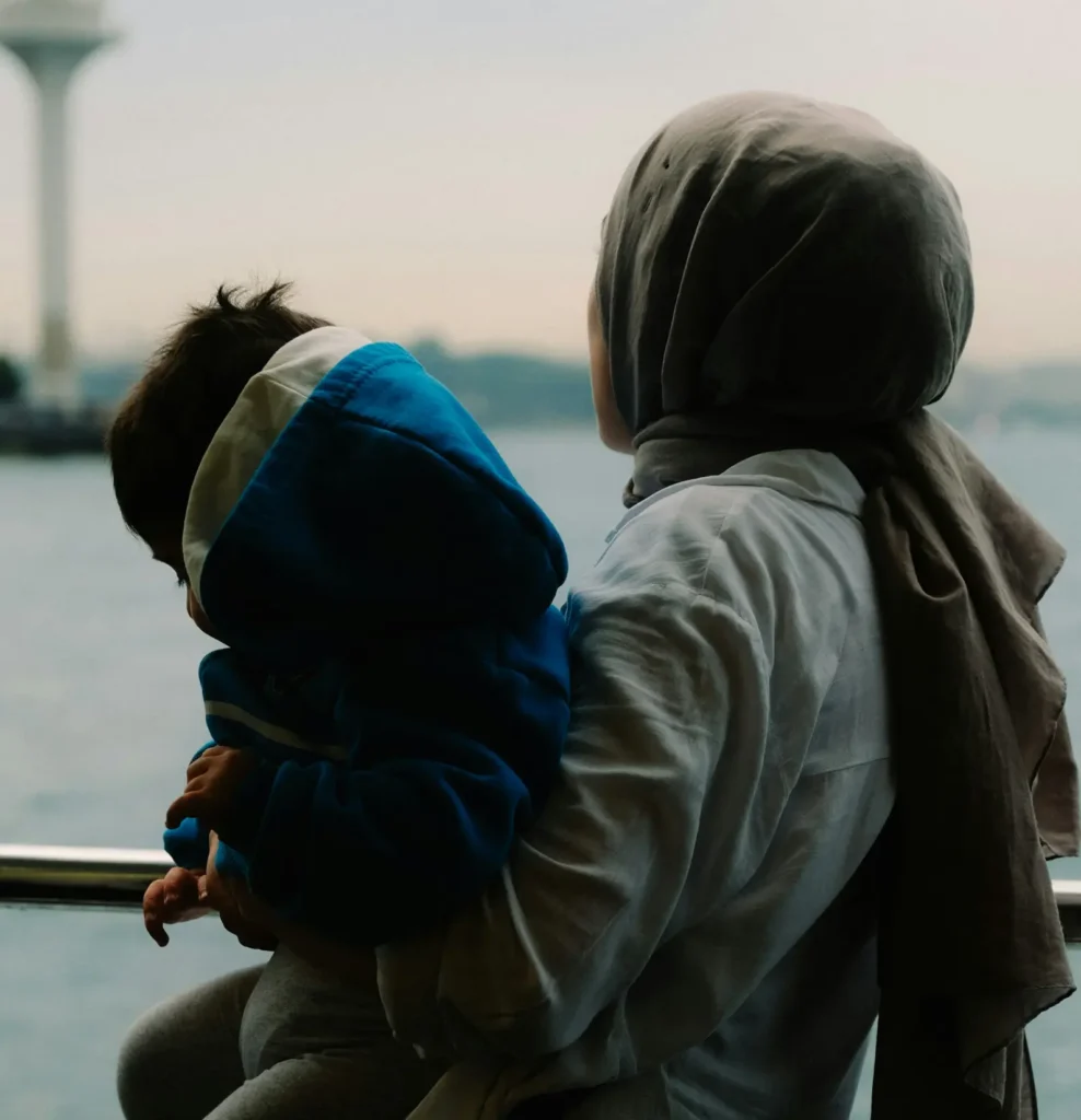 A woman wearing a hijab holding her baby.
