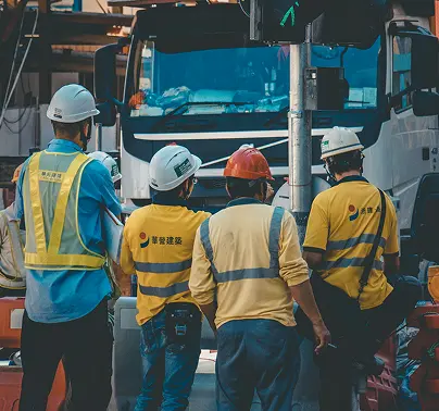 Construction workers looking at a truck