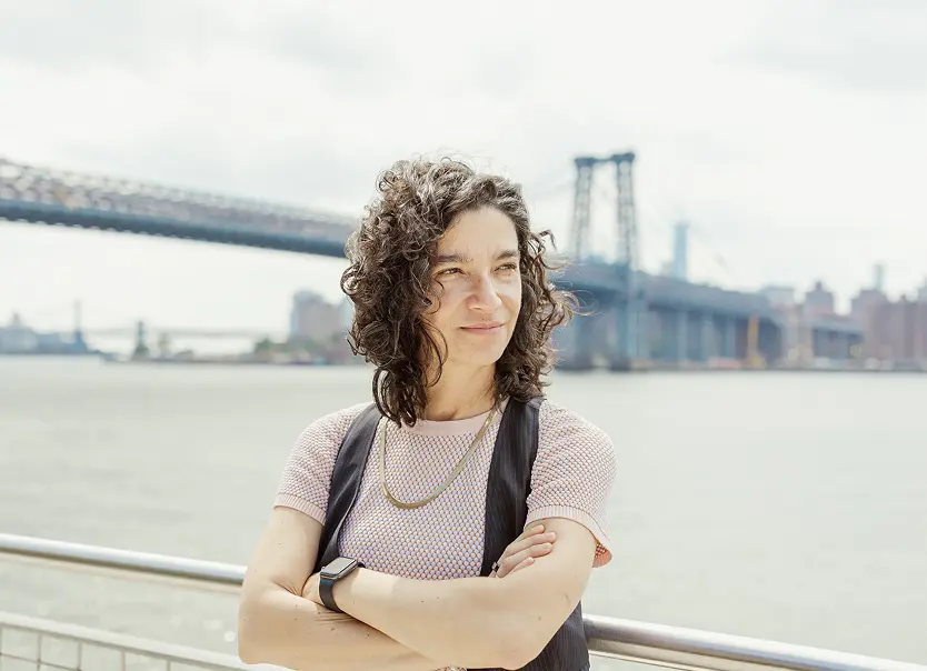 Professional portrait of Lina Stillman standing by a waterfront with a bridge behind her, used in content discussing pay disparity and equal pay in the workplace.